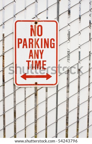 A no parking sign posted on a fence.