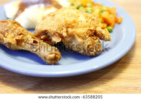 Fried chicken with a side of mashed potatoes, carrots, and green beans.