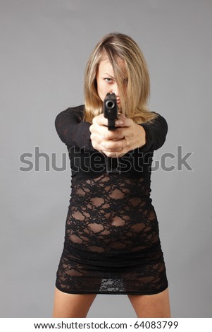 Young and sexy woman in a lace dress with a gun.