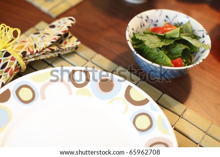 Side salad on a table next to a dish.