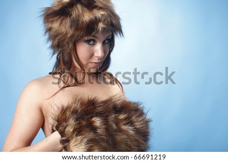 Sexy nude woman wearing fur hat and hand warmer.