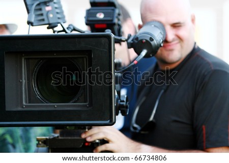 Man with digital cinema camera on movie set.