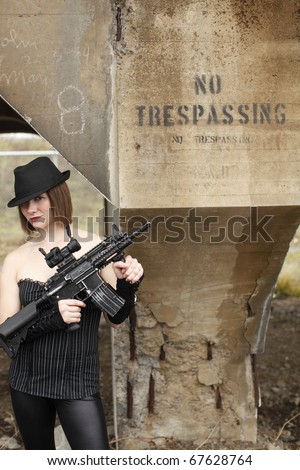 Young and fashionable woman with an assault rifle.