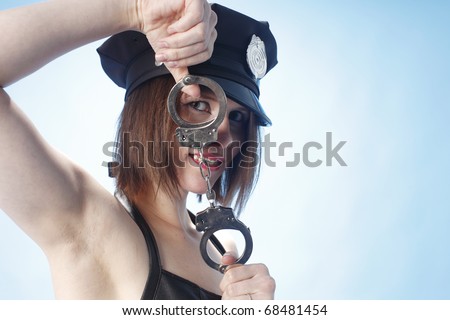 Sexy female police officer playing with handcuffs.