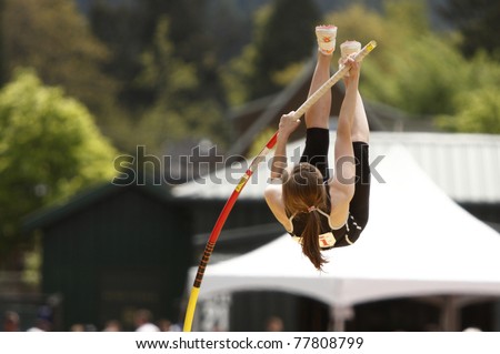 A female athlete competing in the pole vault at a track and field event.