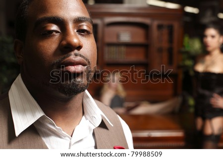 stock photo Man in office with women in lingerie in the background