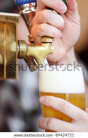 Pulling a beer tap on a fountain at a bar.