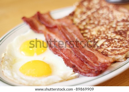 Delicious French toast with bacon and eggs for breakfast.