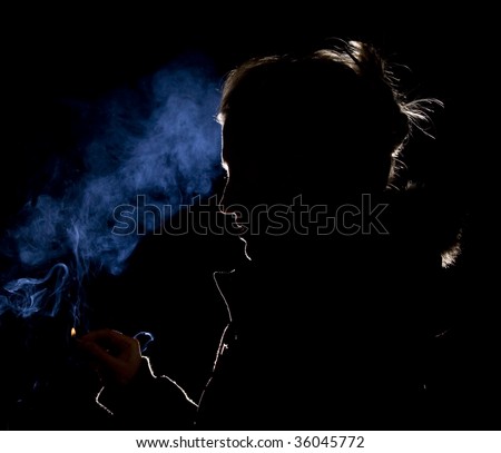 Silhouette or rim light of a Woman lighting a match with blue smoke