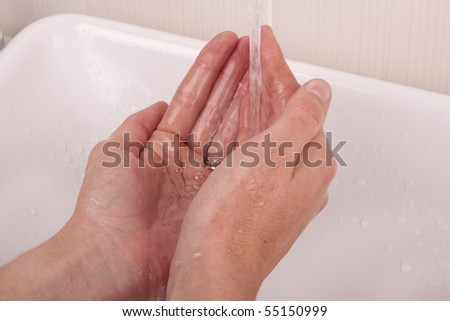 Two hands under a runny tap, washing hands with water