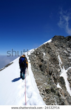 An climber does the last steps before an ascent on the top of mountain