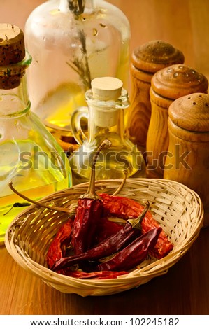 basket with dried chili peppers, olive oil and condiments