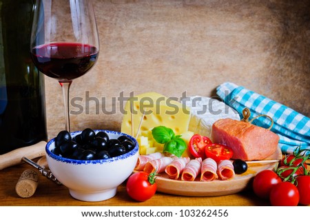 Healthy snacks appetizer with wine, olives, cheese and ham