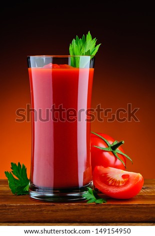 glass of fresh tomato juice and sliced tomato with parsley
