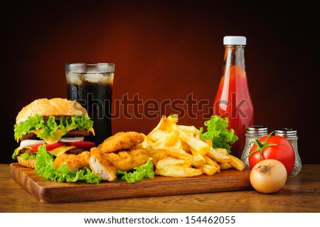 fast food menu with hamburger or cheeseburger, traditional french fries, chicken nuggets, cola and tomato ketchup