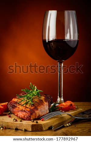 still life with grilled steak, rosemary and glass of red wine