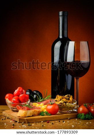still life with spanish tapas, glass and bottle of red wine