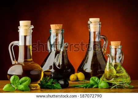 different bottles of infused olive oil with fresh green herbs