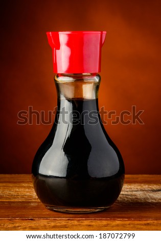 bottle of soy sauce closeup on a wooden plate