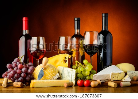 still life with cheese, grapes, red, white and rose wine