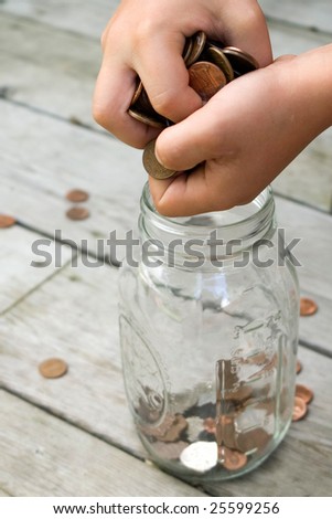 Child places coins into a mason jar for safe-keeping