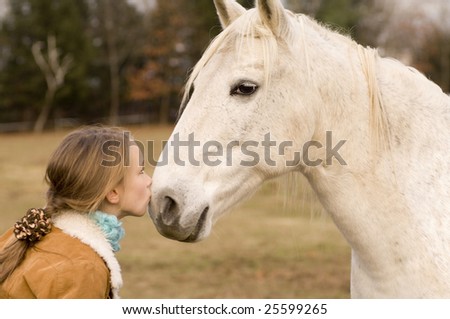 stock photo Young preteen girl kissing a horse on it's muzzle