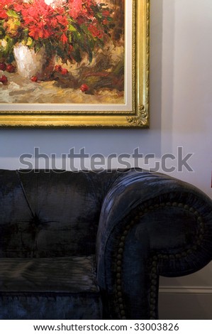 Purple velvet couch under a floral oil painting