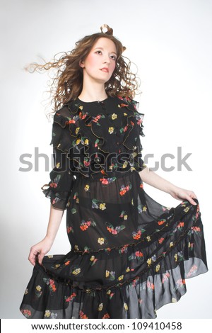 Young dancing woman in flutter vintage dress.