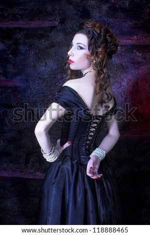Victorian lady.Young woman in black dress and corset.