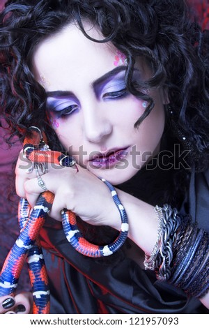 Gorgon. Young woman in dark creative image and with snake.
