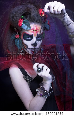 Santa Muerte. Young woman with creative visage and with roses in her hair.