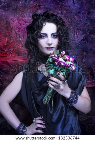 Gorgon. Young woman with dry roses and in dark dramatic image.