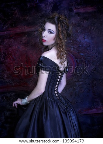 Victorian lady.Young woman in black dress and corset.