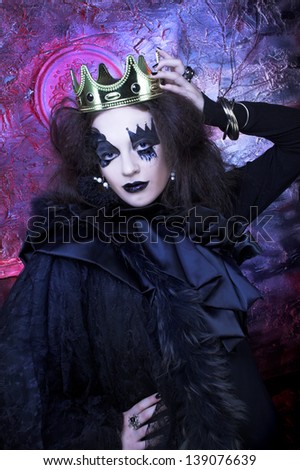 Mad queen. Young woman wotn creative visage and in crown