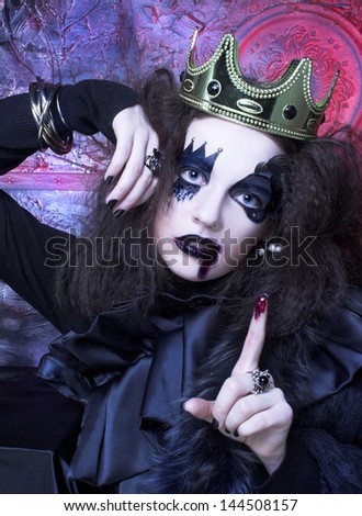 Mad queen. Young woman with creative visage and in crown