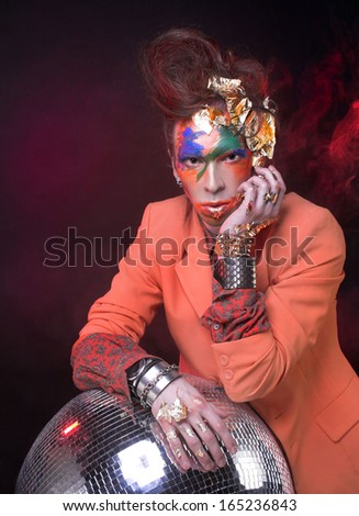 Portrait of young man in creative image with eccentric visage and in stylish cloth.