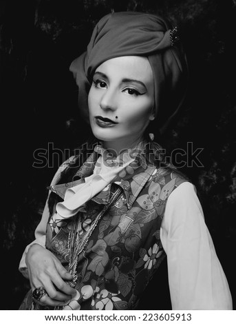 Old photo style. Portrait of young woman in turban and in vintage dress.