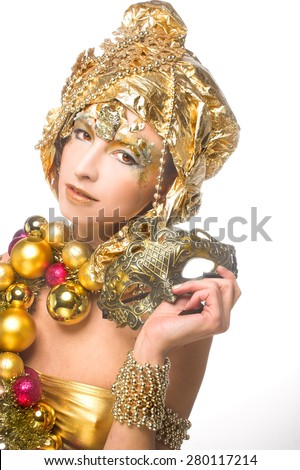 Golden girl. Young woman posing in New year image with holiday  decoration and mask.
