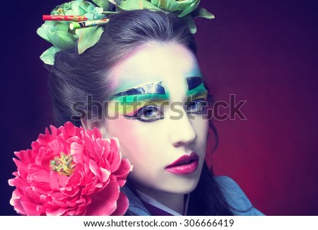 Young woman in creative image in eastern style with flowers in hair.