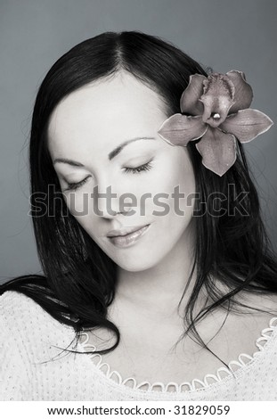 Black and white  portrait of young woman with orchid