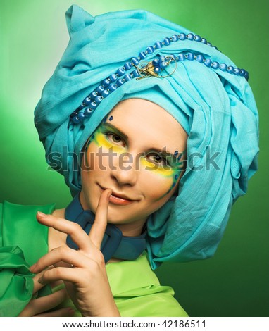 Young smiling woman with creative make-up in blue turban