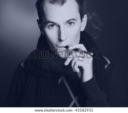 Portrait of young man smoking cigarette. Old photo style.