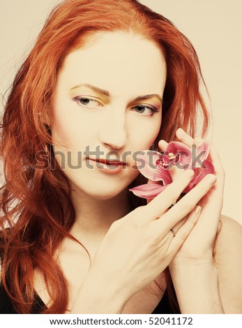 Young woman with pink orchid in her hair