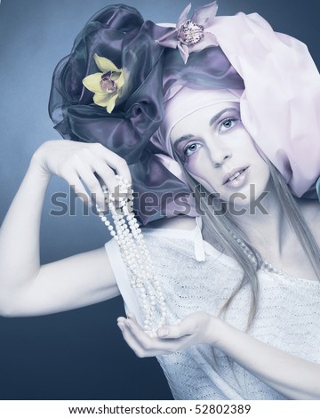 Romantic portrait of young lady with original make-up in cold tones