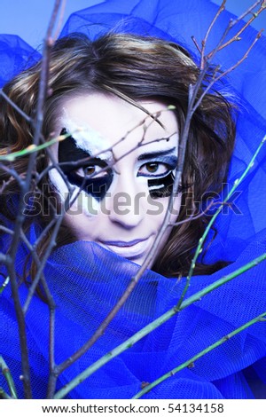 Young woman with creative make-up and twigs