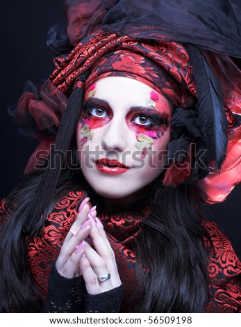 Young stylish lady in black and red silk with creative make-up.