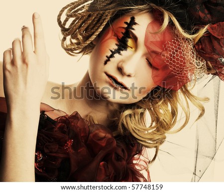 Doll. Young pretty lady with creative make-up and in exotic hat.
