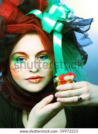 Young woman in creative cloth with sweets