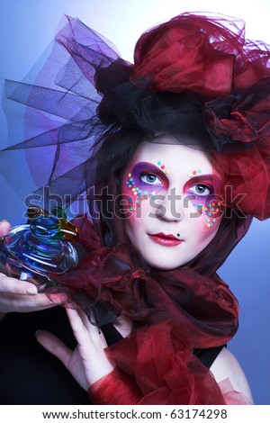 Young lady witn bright make-up in doll-style with glass box and beads in it