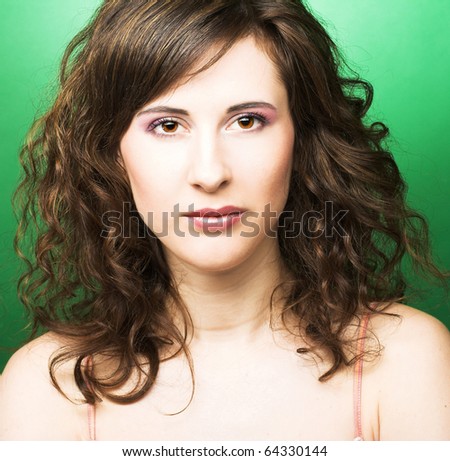 stock photo : Young woman with dark curly hair on green background